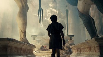 Movie still from “Wrath of the Titans” (2012), directed by Jonathan Liebesman – A man standing in front of a statue of a giant statue; Wide shot, Low angle