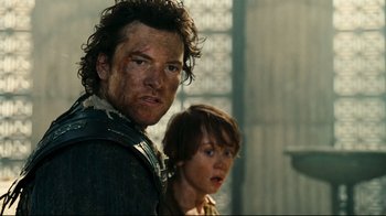 Movie still from “Wrath of the Titans” (2012), directed by Jonathan Liebesman – A man and a boy are standing next to each other; Close Up shot, Over the shoulder angle
