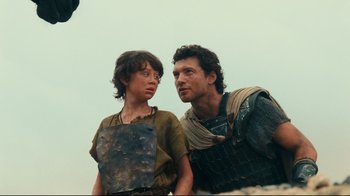 Movie still from “Wrath of the Titans” (2012), directed by Jonathan Liebesman – A man and a boy standing next to each other; Medium shot, Over the shoulder angle