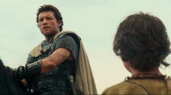Movie still from “Wrath of the Titans” (2012), directed by Jonathan Liebesman – A man in roman garb standing next to another man; Medium shot, Over the shoulder angle