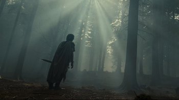 Movie still from “Wrath of the Titans” (2012), directed by Jonathan Liebesman – A person in a forest with a sword; Wide shot, Low angle