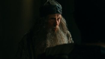 Movie still from “Wrath of the Titans” (2012), directed by Jonathan Liebesman – An old man with long white hair wearing a hat; Close Up shot, Over the shoulder angle