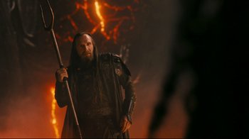 Movie still from “Wrath of the Titans” (2012), directed by Jonathan Liebesman – A man with a beard holding a staff in his hand; Medium shot, Over the shoulder angle