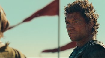 Movie still from “Wrath of the Titans” (2012), directed by Jonathan Liebesman – A person with a flag in the background; Close Up shot, Over the shoulder angle