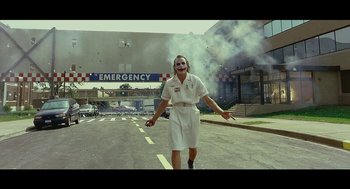 Movie still from “Wrinkles the Clown” (2019), directed by Michael Beach Nichols – A man with a joker mask walking down the street; Extreme Wide shot, Low angle