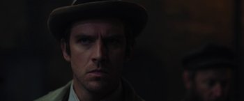 Movie still from “Apostle” (2018), directed by Gareth Evans – A person wearing a hat; Close Up shot, Low angle