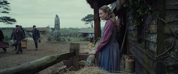 Movie still from “Apostle” (2018), directed by Gareth Evans – A woman standing in front of a wooden fence; Medium shot, Over the shoulder angle