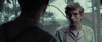 Movie still from “Apostle” (2018), directed by Gareth Evans – Two men standing next to each other near a tree; Close Up shot, Over the shoulder angle