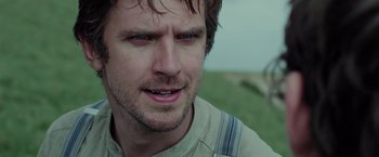 Movie still from “Apostle” (2018), directed by Gareth Evans – A man's face in a grassy field; Close Up shot, Over the shoulder angle