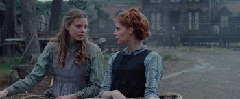 Movie still from “Apostle” (2018), directed by Gareth Evans – Two women are standing next to each other in a field; Close Up shot, Over the shoulder angle