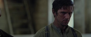 Movie still from “Apostle” (2018), directed by Gareth Evans – A person wearing a shirt and tie; Close Up shot, Over the shoulder angle