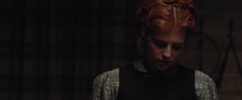 Movie still from “Apostle” (2018), directed by Gareth Evans – A woman with red curly hair is looking down; Close Up shot, Low angle