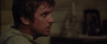 Movie still from “Apostle” (2018), directed by Gareth Evans – A person's face looking to the side; Close Up shot, Over the shoulder angle