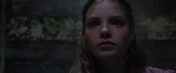 Movie still from “Apostle” (2018), directed by Gareth Evans – A young girl with long blonde hair looking into the distance; Close Up shot, Low angle