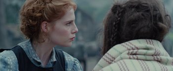 Movie still from “Apostle” (2018), directed by Gareth Evans – A woman with red curly hair looking to her left; Close Up shot, Over the shoulder angle