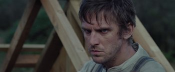 Movie still from “Apostle” (2018), directed by Gareth Evans – A person wearing a shirt; Close Up shot, Over the shoulder angle