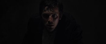 Movie still from “Apostle” (2018), directed by Gareth Evans – A person in a dark room; Close Up shot, Low angle
