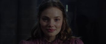 Movie still from “Apostle” (2018), directed by Gareth Evans – A young girl is smiling for the camera; Close Up shot, Over the shoulder angle
