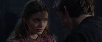 Movie still from “Apostle” (2018), directed by Gareth Evans – A young girl and a young man standing next to each other; Close Up shot, Over the shoulder angle