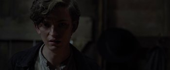 Movie still from “Apostle” (2018), directed by Gareth Evans – A young man is looking into the camera; Close Up shot, Over the shoulder angle