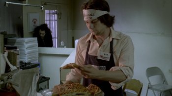 A man wearing a pizza headband and apron