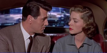 Movie still from “Written on the Wind” (1956), directed by Douglas Sirk – A man and a woman sitting next to each other in a car; Close Up shot, Low angle