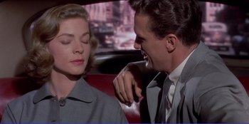 Movie still from “Written on the Wind” (1956), directed by Douglas Sirk – A man and a woman sitting in the back of a car; Close Up shot, Over the shoulder angle