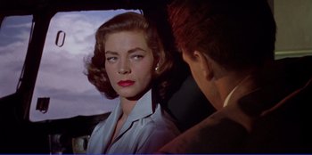 Movie still from “Written on the Wind” (1956), directed by Douglas Sirk – A man and a woman in a car looking at each other; Close Up shot, Over the shoulder angle