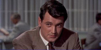 Movie still from “Written on the Wind” (1956), directed by Douglas Sirk – A person wearing a suit and tie; Close Up shot, Over the shoulder angle