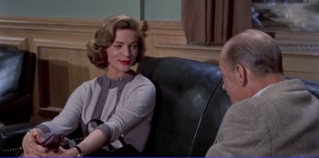 Movie still from “Written on the Wind” (1956), directed by Douglas Sirk – A man and a woman sitting on a couch talking to each other; Medium shot, Over the shoulder angle