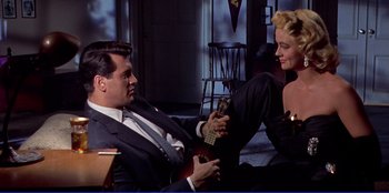 Movie still from “Written on the Wind” (1956), directed by Douglas Sirk – A man and a woman sitting on the floor with a guitar; Medium shot, Low angle