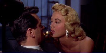 Movie still from “Written on the Wind” (1956), directed by Douglas Sirk – A man and a woman are kissing in a room; Close Up shot, Low angle