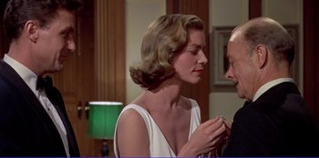 Movie still from “Written on the Wind” (1956), directed by Douglas Sirk – A man and a woman are holding hands; Medium shot, Over the shoulder angle