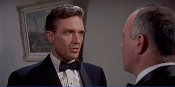 Movie still from “Written on the Wind” (1956), directed by Douglas Sirk – A man in a tuxedo talking to another man in a suit; Close Up shot, Over the shoulder angle