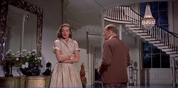 Movie still from “Written on the Wind” (1956), directed by Douglas Sirk – A man and a woman standing next to each other in a room; Medium shot, Low angle