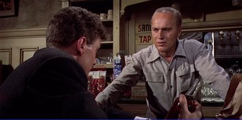 Movie still from “Written on the Wind” (1956), directed by Douglas Sirk – Two men sitting at a table in front of each other; Medium shot, Over the shoulder angle