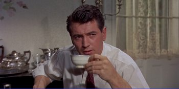 Movie still from “Written on the Wind” (1956), directed by Douglas Sirk – A person holding a cup of coffee; Close Up shot, Low angle