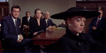 Movie still from “Written on the Wind” (1956), directed by Douglas Sirk – A group of people sitting around a table; Medium shot, Over the shoulder angle