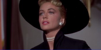 Movie still from “Written on the Wind” (1956), directed by Douglas Sirk – A person wearing a hat and a necklace; Close Up shot, Low angle