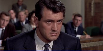 Movie still from “Written on the Wind” (1956), directed by Douglas Sirk – A person wearing a suit and tie; Close Up shot, Over the shoulder angle