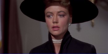 Movie still from “Written on the Wind” (1956), directed by Douglas Sirk – A person wearing a hat and a necklace; Close Up shot, Over the shoulder angle