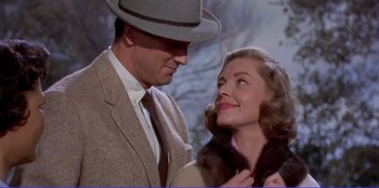 Movie still from “Written on the Wind” (1956), directed by Douglas Sirk – A man and a woman standing next to each other; Close Up shot, Low angle