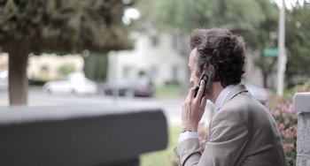 Movie still from “Wrong” (2012), directed by Quentin Dupieux – A man is talking on a cell phone outside; Close Up shot, Low angle