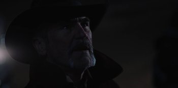 Movie still from “Yellowstone” (2018), created by John Linson – An old man with a beard wearing a black hat; Close Up shot, Low angle