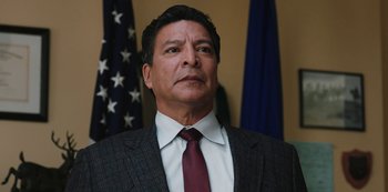 Movie still from “Yellowstone” (2018), created by John Linson – A person wearing a suit and a tie; Close Up shot, Low angle