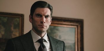 Movie still from “Yellowstone” (2018), created by John Linson – A man in a suit and a tie; Close Up shot, Low angle