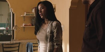 Movie still from “Yellowstone” (2018), created by John Linson – A woman standing in front of a shelf; Medium shot, Over the shoulder angle