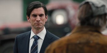 Movie still from “Yellowstone” (2018), created by John Linson – A man in a suit and a tie; Close Up shot, Over the shoulder angle
