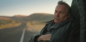 Movie still from “Yellowstone” (2018), created by John Linson – A person with his arms crossed; Close Up shot, Low angle