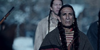 Movie still from “Yellowstone” (2018), created by John Linson – Two native american men standing in the snow; Close Up shot, Over the shoulder angle